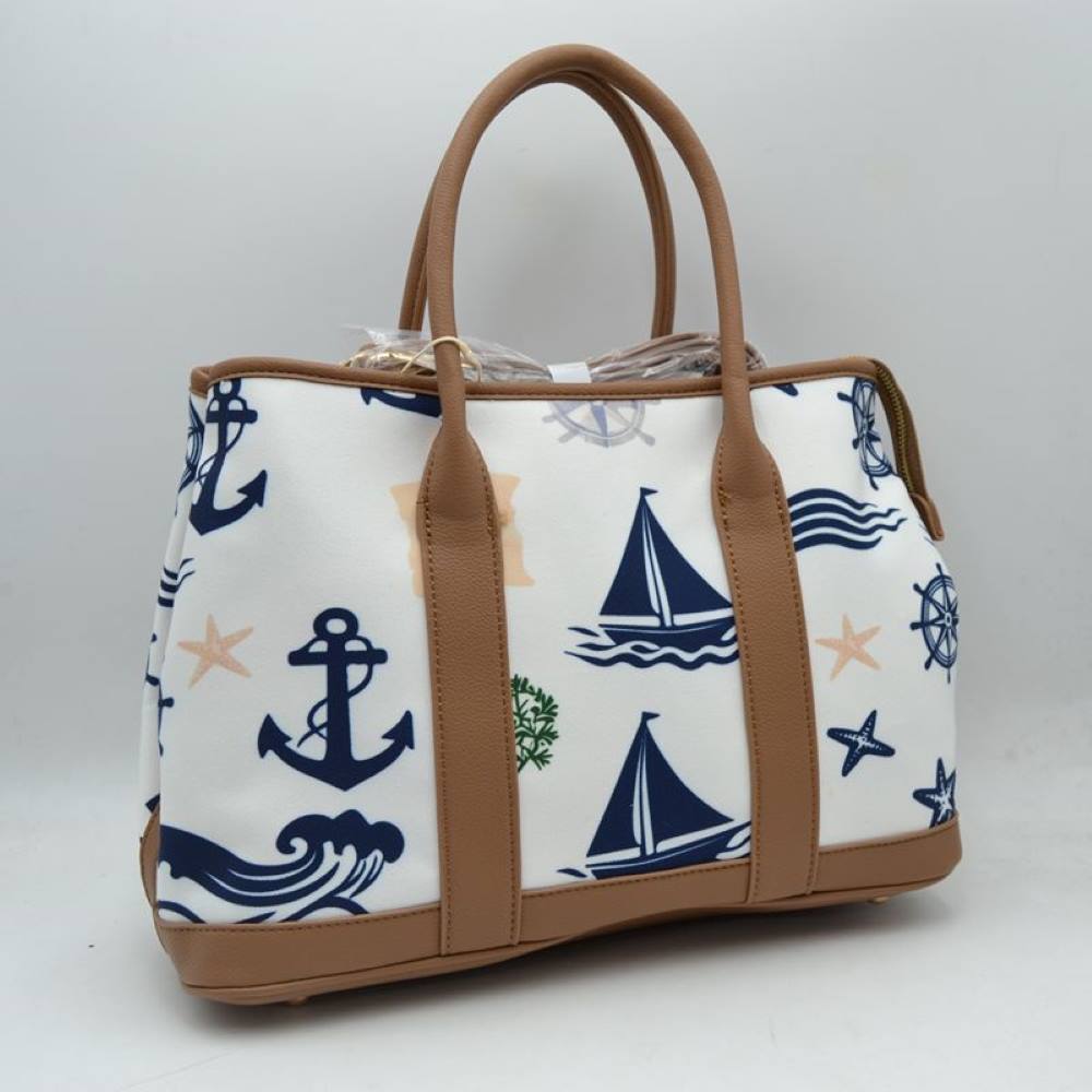 Taupe Set sail with this nautical-inspired canvas tote. Featuring a crisp backdrop decorated with a classic print of anchors, sailboats, ship wheels, and ocean waves, this bag is the perfect accessory for coastal getaways or adding maritime flair to your daily ensemble. Framed with structured textured trim, it balances casual resort style with sharp, everyday functionality.