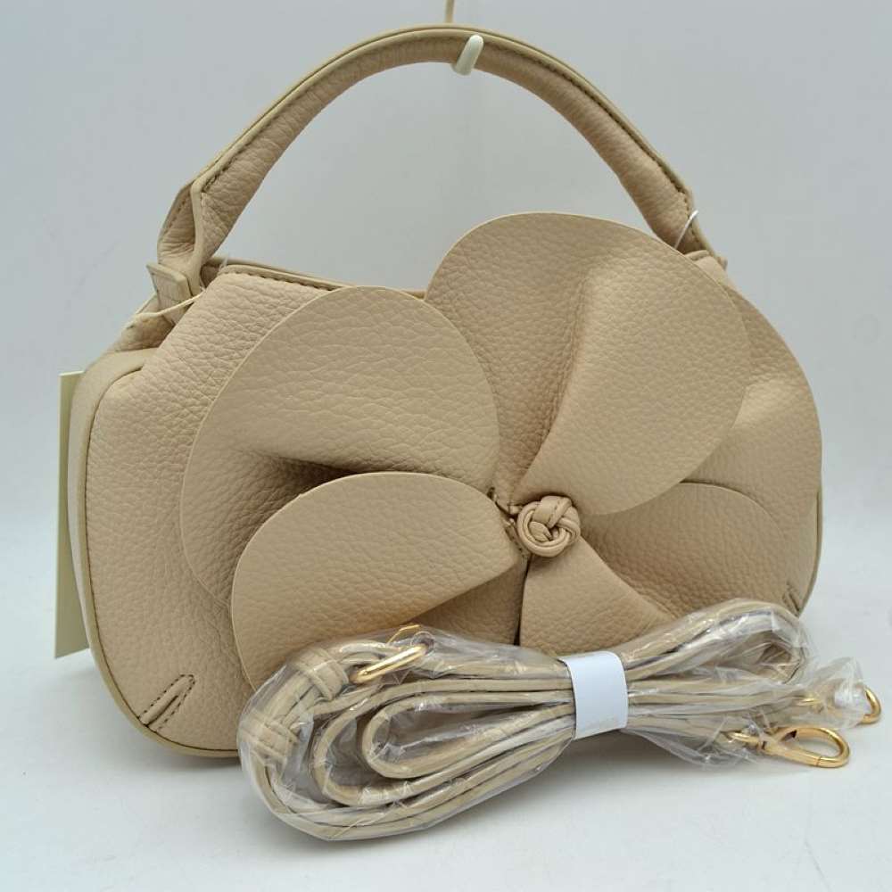 Taupe Make a striking fashion statement with this avant-garde pebble-grain handbag. Defined by its dramatic, oversized three-dimensional leather flower overlay on the front panel, this unique bag effortlessly bridges the gap between modern sculptural art and functional everyday luxury.