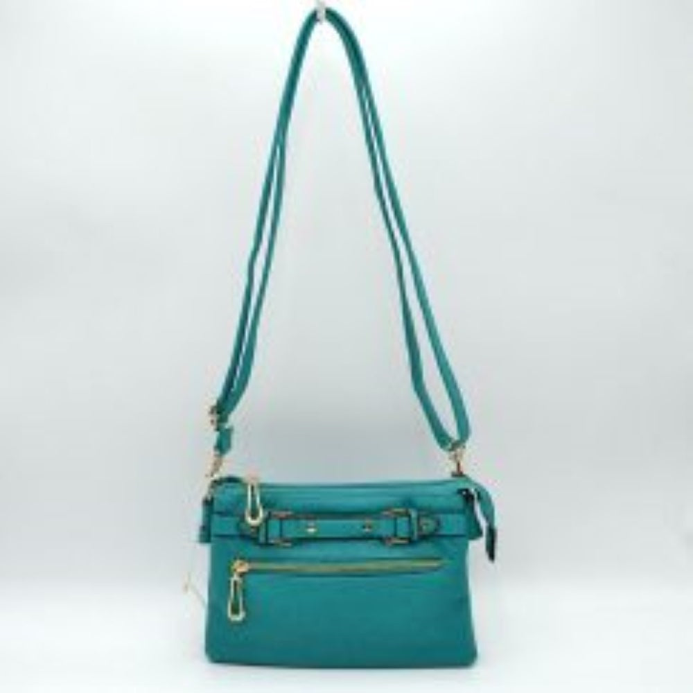 Turquoise This functional crossbody bag is designed for organized everyday use, featuring a textured exterior equipped with multiple secure storage compartments. The front panel includes a convenient horizontal zippered pocket accented with an oversized metallic zipper pull, situated beneath a decorative horizontal band detailed with metallic studs and loops.