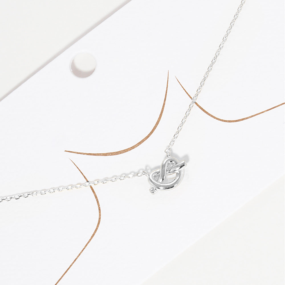 White Gold Dipped Knotted Heart Pendant Necklace features a delicate and intricate design perfect for any occasion. The heart pendant is coated in lustrous gold, adding a touch of elegance to the piece. Make a statement with this beautiful necklace that is both stylish and timeless.