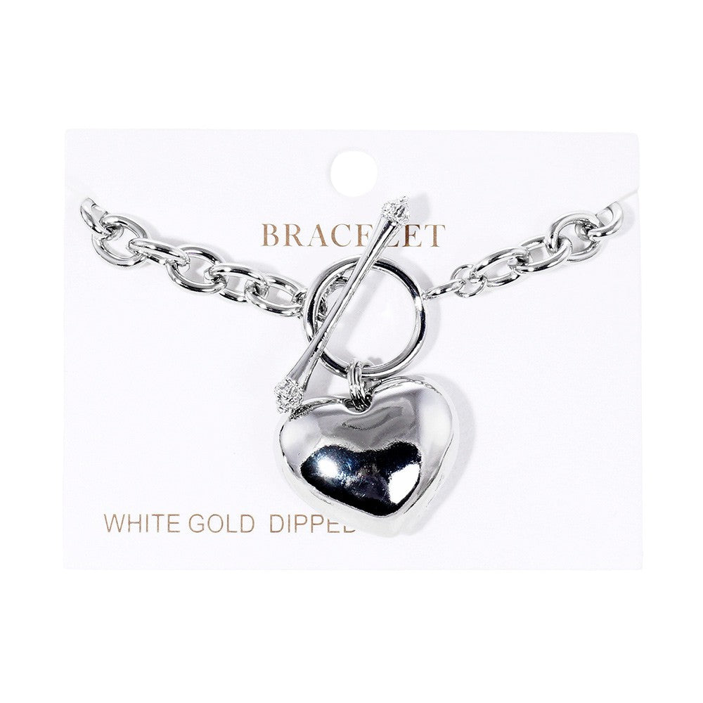 Rhodium White Gold Dipped Metal Heart Charm Toggle Bracelet is a stunning addition to any jewelry collection. Crafted with precision and dipped in white gold, the heart charm adds a touch of elegance to any outfit. The toggle closure ensures a secure fit, perfect for everyday wear or special occasions.