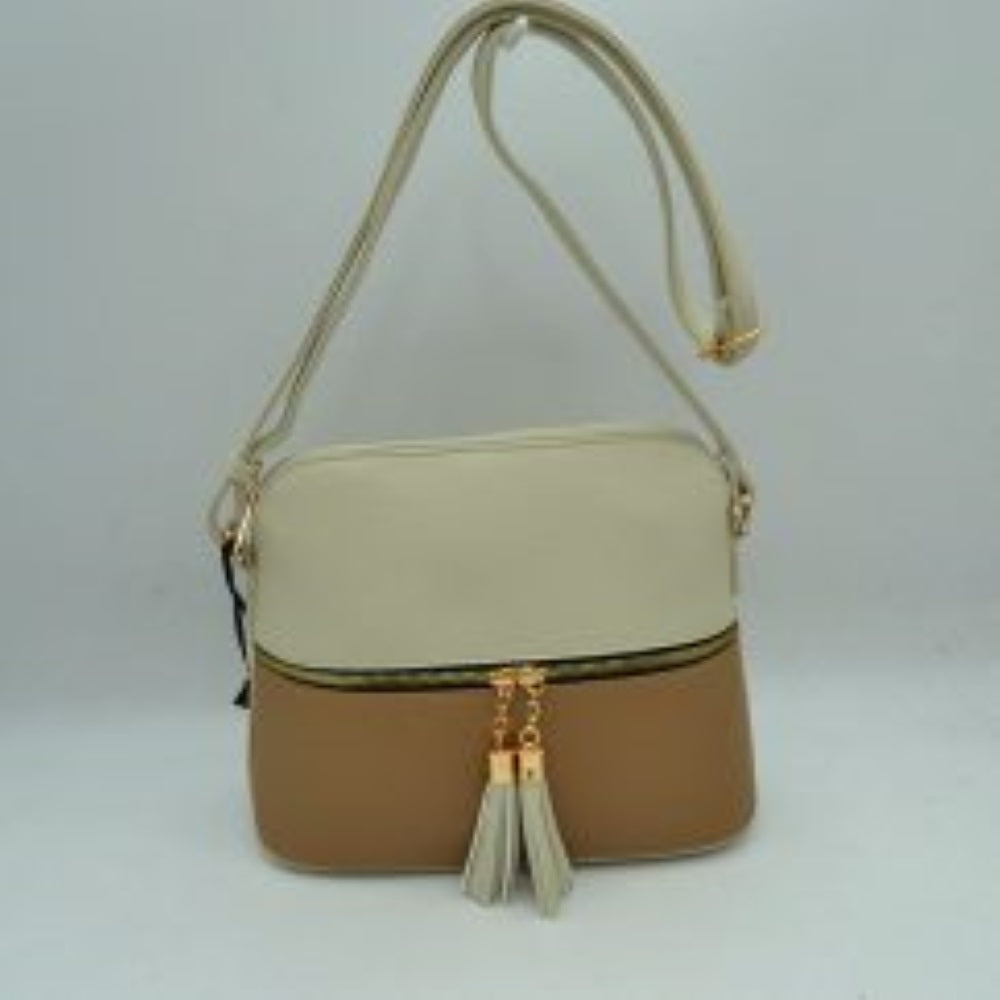 White-Taupe This everyday crossbody bag features a structured pebbled texture body with a distinct two-toned paneled design. Ideal for organized daily use, it showcases a prominent horizontal front zipper with dual gold-toned pulls, each adorned with a decorative hanging fringe tassel. The main storage compartment is paired with a matching long