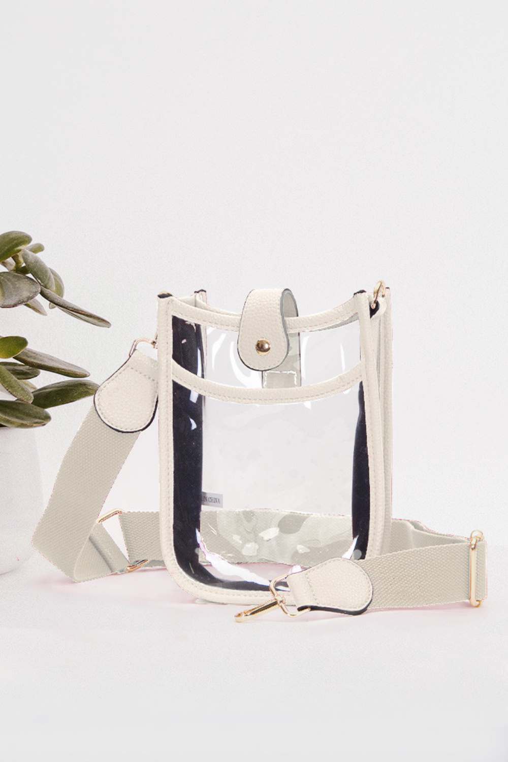 White Perfect for concert season and stadium events, this clear crossbody mini bag meets all venue security requirements while keeping your essentials within reach. Crafted from durable 100% PVC, it's easy to clean and built to last through countless outings. Compact yet functional at 8" x 5.8" x 2.3", the adjustable crossbody strap sits comfortably across your body, leaving your hands free. The transparent design lets you quickly locate your phone, keys, and small valuables at a glance.