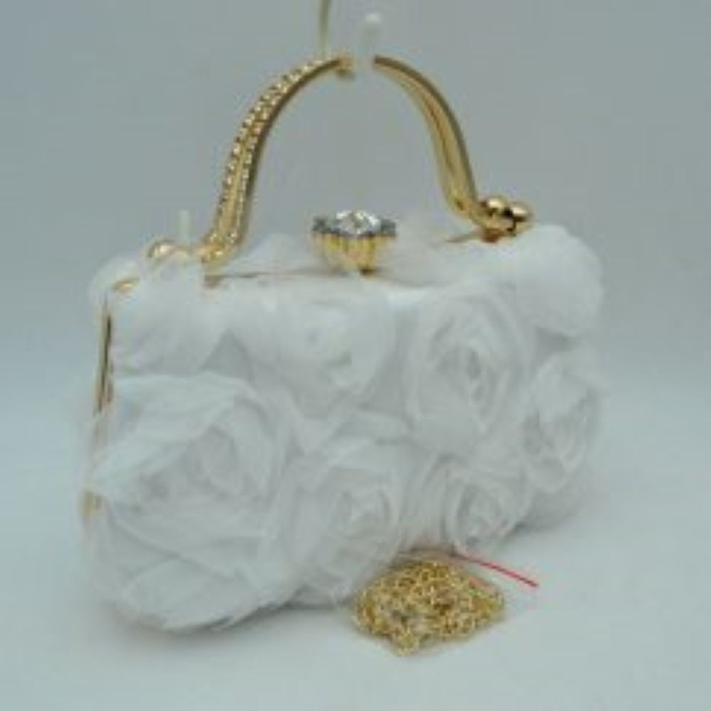 White Make an elegant impression at your next formal event with this stunning evening clutch bag. The exterior features a beautiful arrangement of multi-dimensional, textured rosettes that create a soft floral pattern over a smooth base fabric. A polished, metallic top handle arches elegantly over the structured frame, while a prominent rhinestone-encrusted clasp closure sits at the top to secure your essentials with a touch of brilliant sparkle. Perfect for weddings, galas