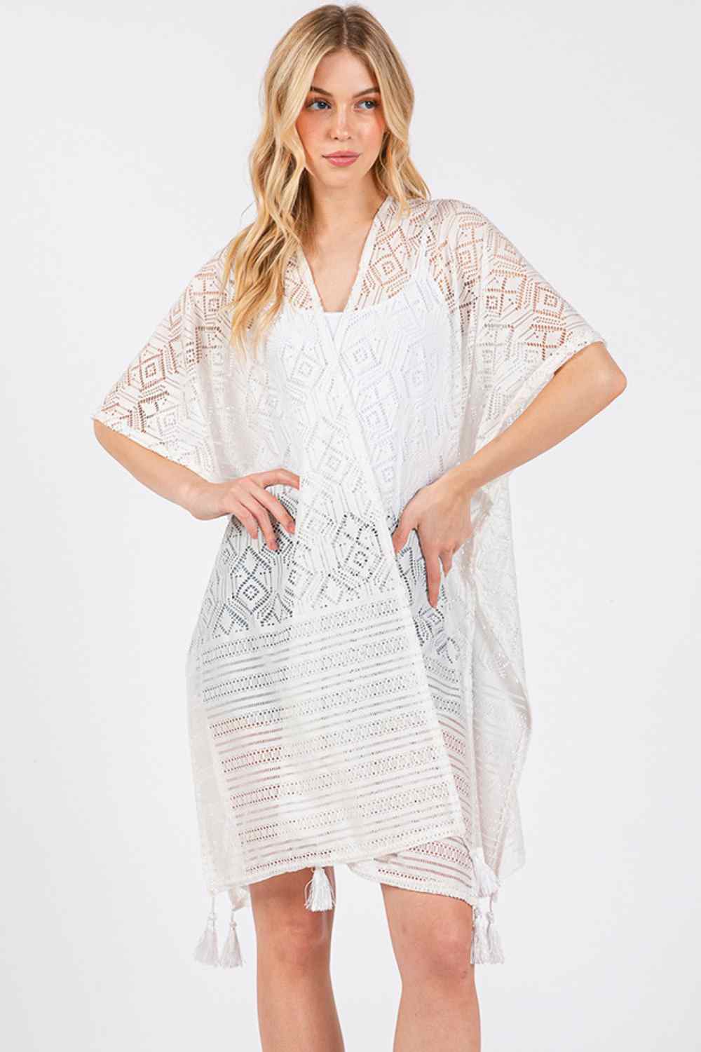 White Elevate your beach style with this eye-catching geometric pattern cover up. Featuring a vibrant design paired with playful tassels, this lightweight piece is perfect for layering over your swimsuit. The solid construction ensures durability while the breathable polyester fabric keeps you cool and comfortable in the summer heat. Measuring 35" x 33", it offers generous coverage for the pool or beach. An essential addition to any warm-weather wardrobe.