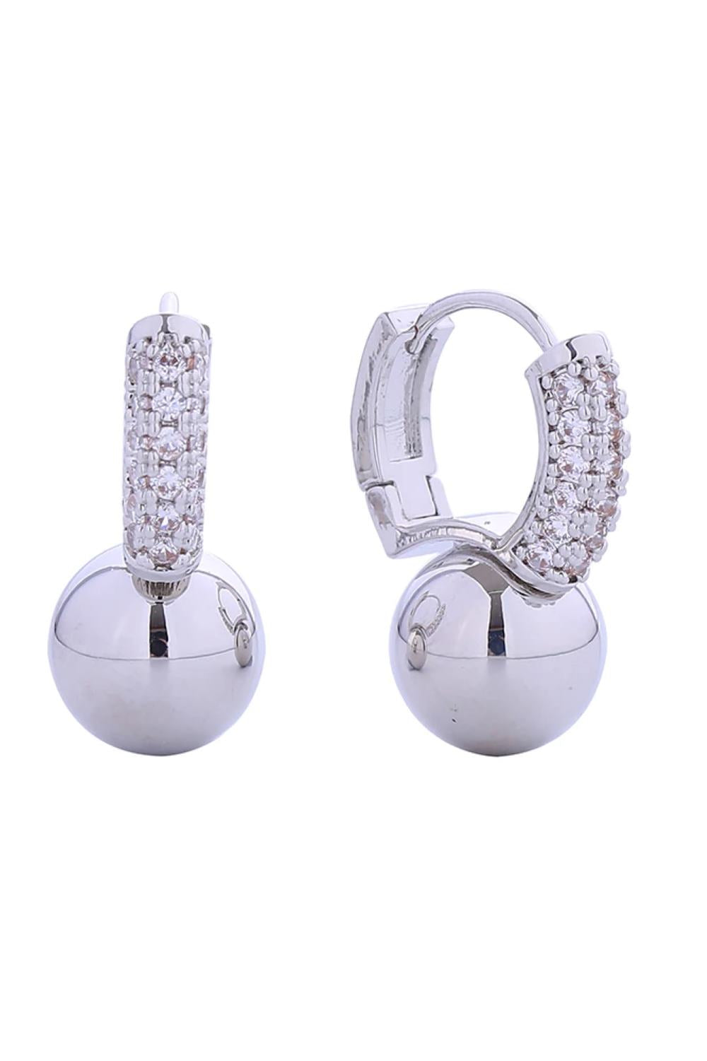 White Gold Timeless huggie earrings with a graceful ball drop accent, embellished with sparkling pavé cubic zirconia. Constructed from hypoallergenic brass with 14K gold or white gold plating for an upscale look. The compact 1.7cm diameter sits comfortably close to the ear for an understated elegance.