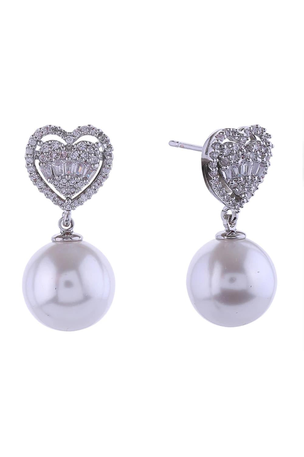 White Gold Elegant pearl dangle earrings featuring a sparkling crystal heart top, dipped in lustrous 14K gold or white gold plating. Crafted from hypoallergenic brass with cubic zirconia accents and genuine pearls for timeless sophistication. Measuring 2.5cm in diameter, these earrings offer the perfect balance of statement style and wearable comfort. Lead and nickel compliant, making them safe for sensitive skin. Expertly made in Korea with attention to quality craftsmanship.