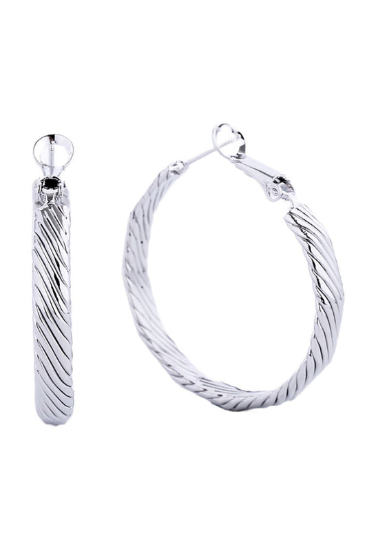 White Gold Elegant hoop earrings crafted from hypoallergenic brass with a luxurious 14K gold and white dip finish. Featuring a secure omega closure for all-day wear, these 3.5cm diameter hoops offer timeless style with modern comfort. Lead and nickel compliant, making them perfect for sensitive skin. A versatile essential that transitions effortlessly from casual to formal occasions.