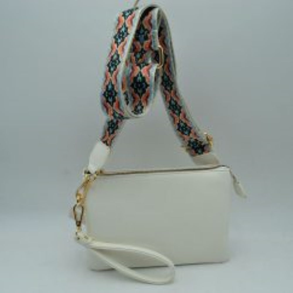 White This versatile clutch is designed for seamless everyday transition and features multiple carrying options to suit your style. It is equipped with secure top zipper compartments to keep your daily essentials safely organized and within reach. For carrying flexibility, the bag comes with both a matching wristlet loop and a wide, adjustable shoulder strap decorated with a detailed geometric woven pattern, both attaching easily via sturdy metallic clasps.