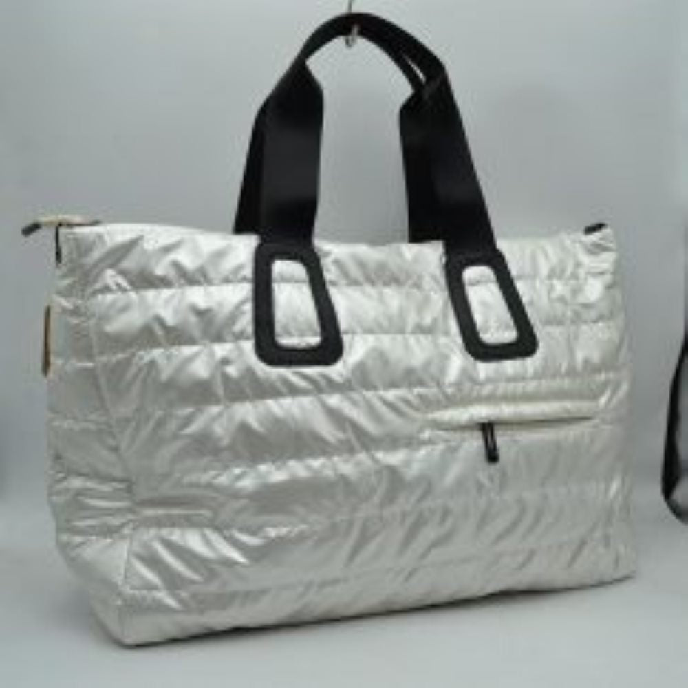 White Upgrade your travel gear with this exceptionally spacious, lightweight weekender duffel bag, perfect for overnight trips, gym sessions, or casual weekend getaways. Featuring a stylish horizontally quilted puffer design, this bag combines a cozy, modern aesthetic with highly practical function. It is designed with wide, durable webbed top handles for a comfortable grip, alongside a matching adjustable and detachable shoulder strap secured by polished metallic clasps for easy hands-free carrying.