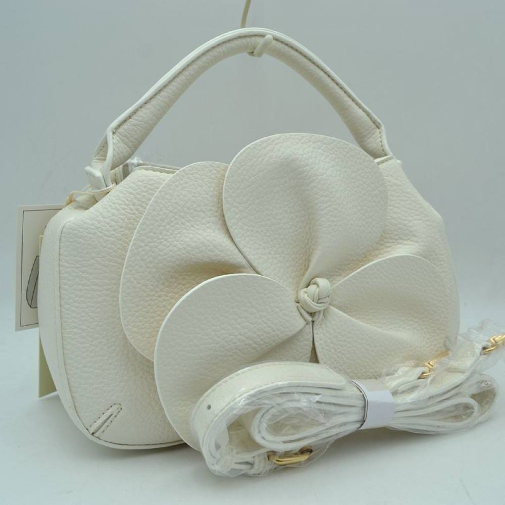 White Make a striking fashion statement with this avant-garde pebble-grain handbag. Defined by its dramatic, oversized three-dimensional leather flower overlay on the front panel, this unique bag effortlessly bridges the gap between modern sculptural art and functional everyday luxury.