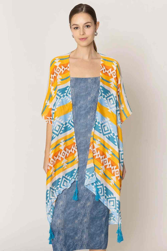 Yellow Embrace bohemian elegance with this striking Aztec Pattern Print Tassel Kimono. Crafted from lightweight 100% polyester, this versatile piece features bold geometric patterns inspired by traditional Aztec designs, complete with decorative tassels for added flair. Perfect for layering over any outfit, this kimono measures 35.4" x 35.4", offering a relaxed, flowing fit that flatters all body types.