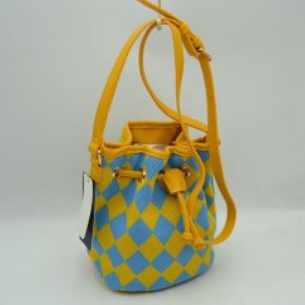 Yellow This everyday bucket bag features a distinctive argyle diamond pattern across its structured main body. Ideal for daily use, it is designed with a long, adjustable shoulder strap connected via metallic side rings. The spacious main storage compartment features an open-top design that closes with a functional drawstring woven through integrated metallic grommets along the upper rim, securing at the front with a knotted tie accent.