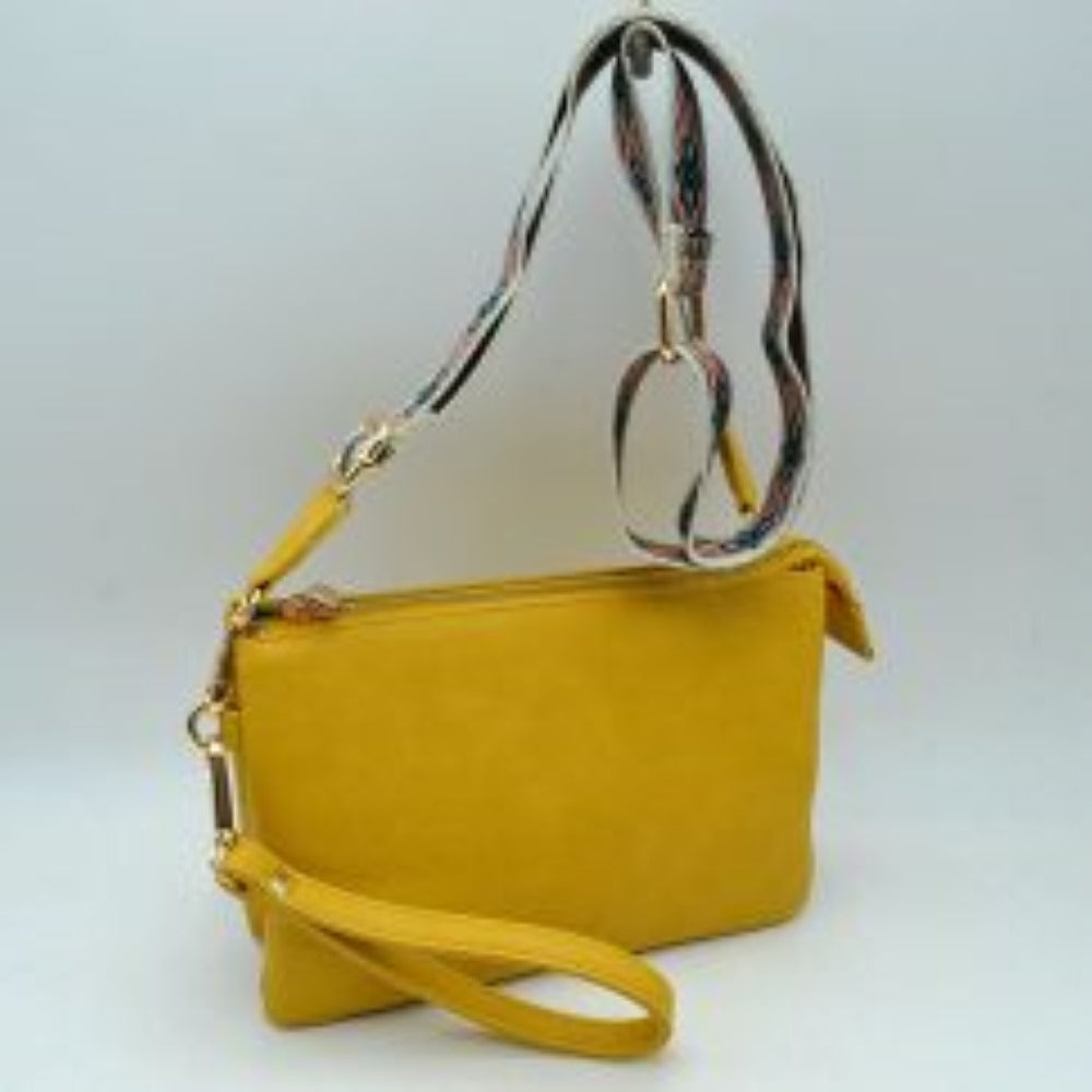 Yellow This versatile clutch is designed for seamless everyday transition and features multiple carrying options to suit your style. It is equipped with secure top zipper compartments to keep your daily essentials safely organized and within reach. For carrying flexibility, the bag comes with both a matching wristlet loop and a wide, adjustable shoulder strap decorated with a detailed geometric woven pattern, both attaching easily via sturdy metallic clasps.