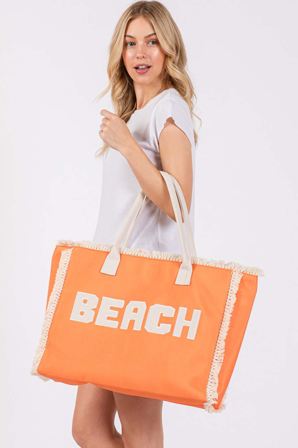Orange BEACH Embroidered Letter Fringe Summer Tote Bag combines style and practicality for your warm-weather outings. Crafted with durable materials, it features detailed embroidered lettering and playful fringe accents that enhance its summery appeal. Spacious enough to carry essentials, this tote is perfect for beach days or casual errands, offering both functionality and a distinctive, expert-crafted design.