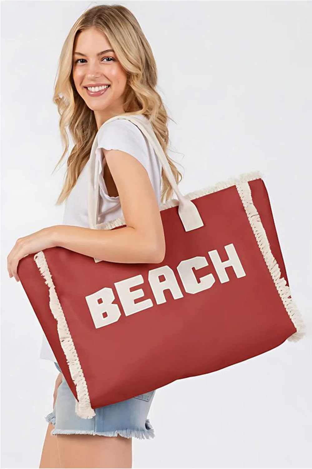 Red BEACH Embroidered Letter Fringe Summer Tote Bag combines style and practicality for your warm-weather outings. Crafted with durable materials, it features detailed embroidered lettering and playful fringe accents that enhance its summery appeal. Spacious enough to carry essentials, this tote is perfect for beach days or casual errands, offering both functionality and a distinctive, expert-crafted design.