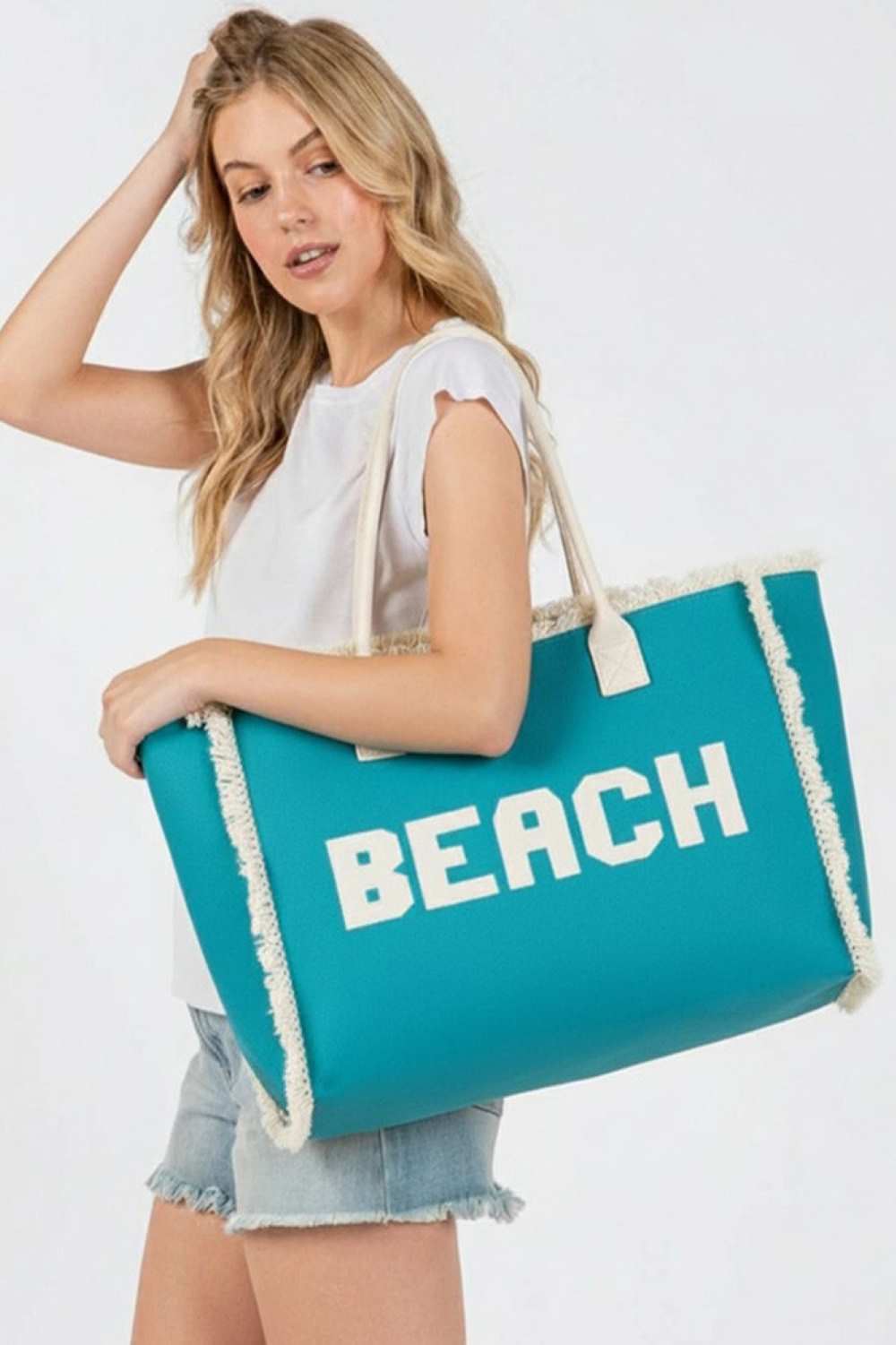 Teal BEACH Embroidered Letter Fringe Summer Tote Bag combines style and practicality for your warm-weather outings. Crafted with durable materials, it features detailed embroidered lettering and playful fringe accents that enhance its summery appeal. Spacious enough to carry essentials, this tote is perfect for beach days or casual errands, offering both functionality and a distinctive, expert-crafted design.