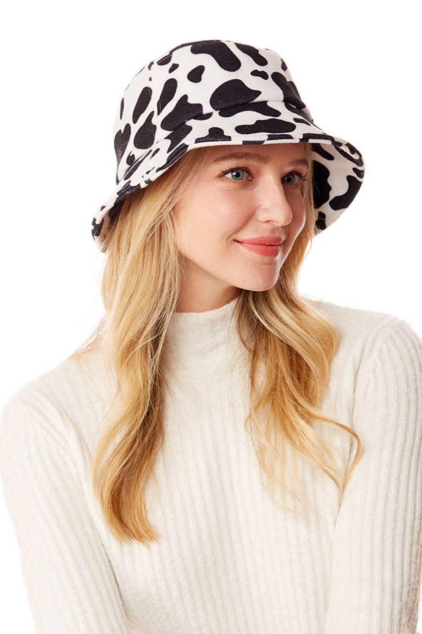 White Cow Print Bucket Hat combines a classic silhouette with a trending animal print design. The distinctive black and white pattern offers versatile styling options while providing effective sun protection. Constructed with quality materials for durability, this statement accessory elevates casual outfits with its fashionable farm-inspired aesthetic. 