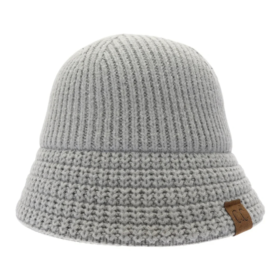 Light grey Knitted Cloche C.C Bucket Hat combines classic cloche styling with the casual appeal of a bucket hat, crafted from soft, durable knit fabric. Its structured yet flexible design offers comfortable wear and a flattering fit, making it an ideal accessory for cooler seasons. This hat offers both warmth and style, making it perfect for adding a sophisticated edge to everyday outfits. 