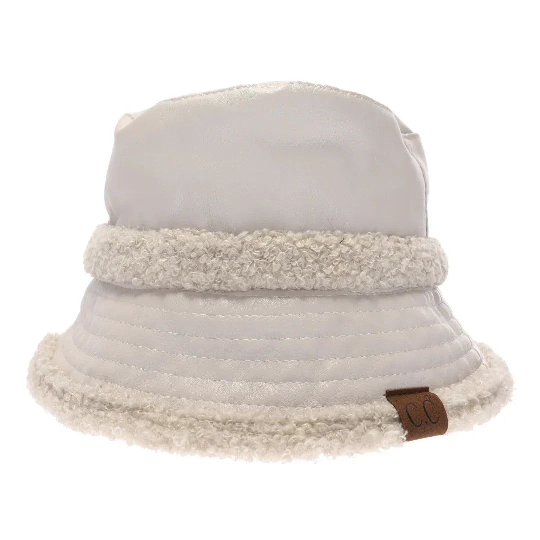 Dove Soft Faux Leather Shearling C.C Bucket Hat combines premium faux leather with a plush shearling lining to deliver exceptional warmth and comfort. Designed with a classic bucket silhouette, this hat offers a refined, expert-level accessory that enhances cold-weather outfits while providing durable protection against the elements. Its soft texture and thoughtful construction make it a sophisticated choice for those seeking both style and functionality. 