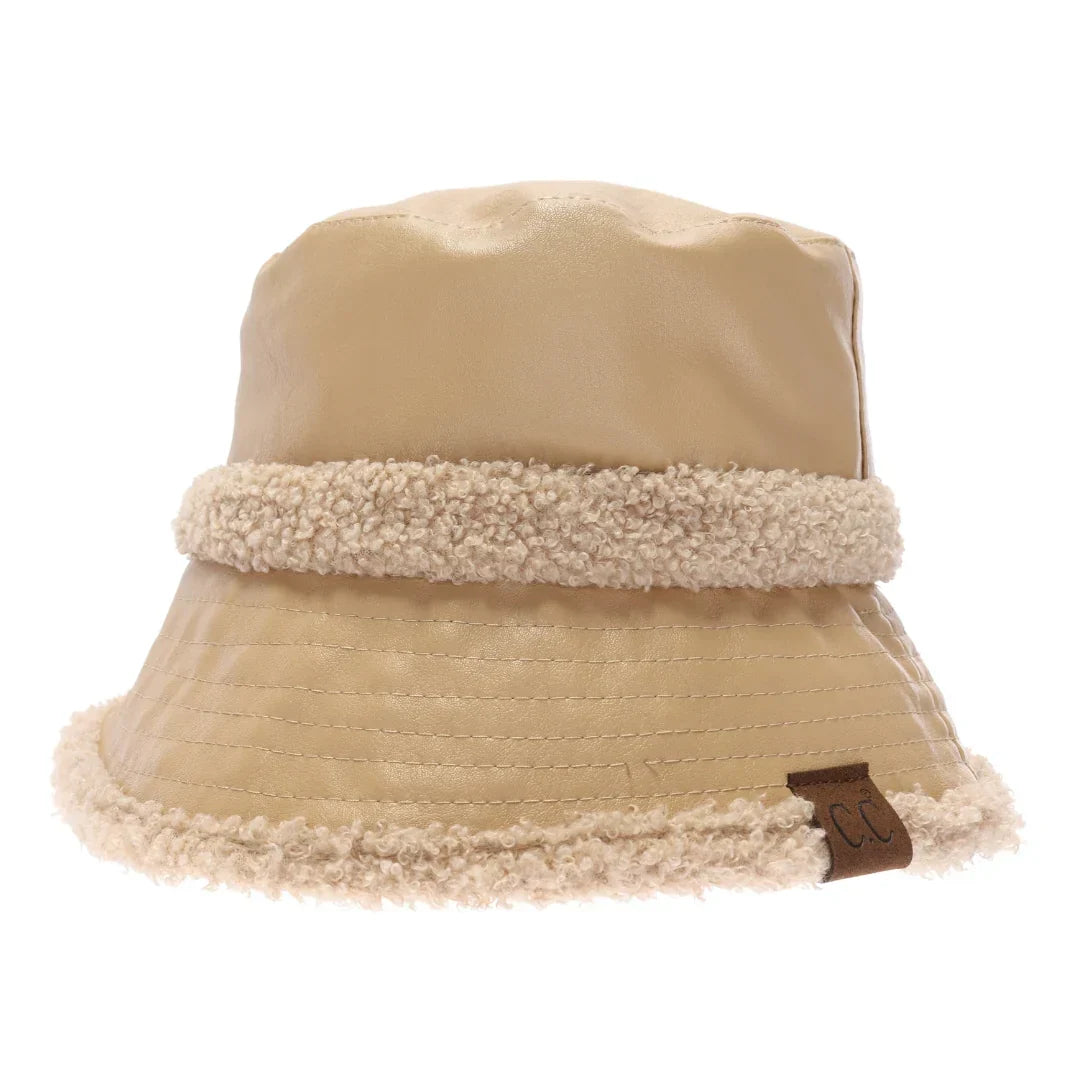 Nude Soft Faux Leather Shearling C.C Bucket Hat combines premium faux leather with a plush shearling lining to deliver exceptional warmth and comfort. Designed with a classic bucket silhouette, this hat offers a refined, expert-level accessory that enhances cold-weather outfits while providing durable protection against the elements. Its soft texture and thoughtful construction make it a sophisticated choice for those seeking both style and functionality. 