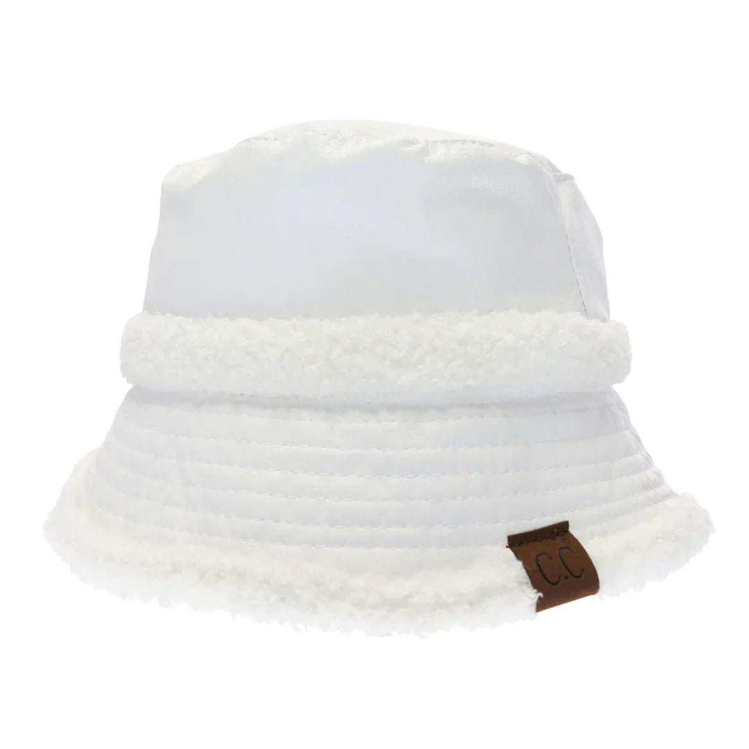 White- Soft Faux Leather Shearling C.C Bucket Hat combines premium faux leather with a plush shearling lining to deliver exceptional warmth and comfort. Designed with a classic bucket silhouette, this hat offers a refined, expert-level accessory that enhances cold-weather outfits while providing durable protection against the elements. Its soft texture and thoughtful construction make it a sophisticated choice for those seeking both style and functionality. 