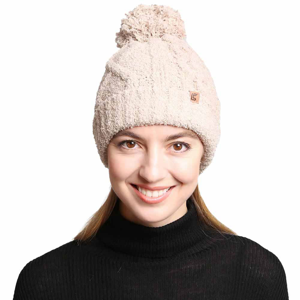 Beige Solid Color Cable Knit Beanie. Accessorize the fun way with this pom cable knit Beanie. The autumnal touch you need to finish your outfit in style. Cable knit Beanie made with warm poly microfiber to ensure maximum comfort and durability. Ideal winter head cover! Comes in one size winter cap with a pom that fits most head sizes. Absolutely the perfect gift winter accessory!