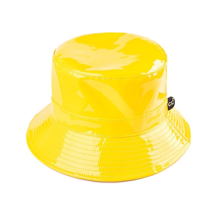 Yellow C.C Brand Shiny Solid Color Reflective Enamel Detailed Rain Bucket Hat; this rain hat is snug on the head and works well to keep rain off the head, out of eyes, and also the back of the neck. Wear it to lend a modern liveliness above a raincoat on trans-seasonal days in the city. Perfect Gift for fashion-forward friend